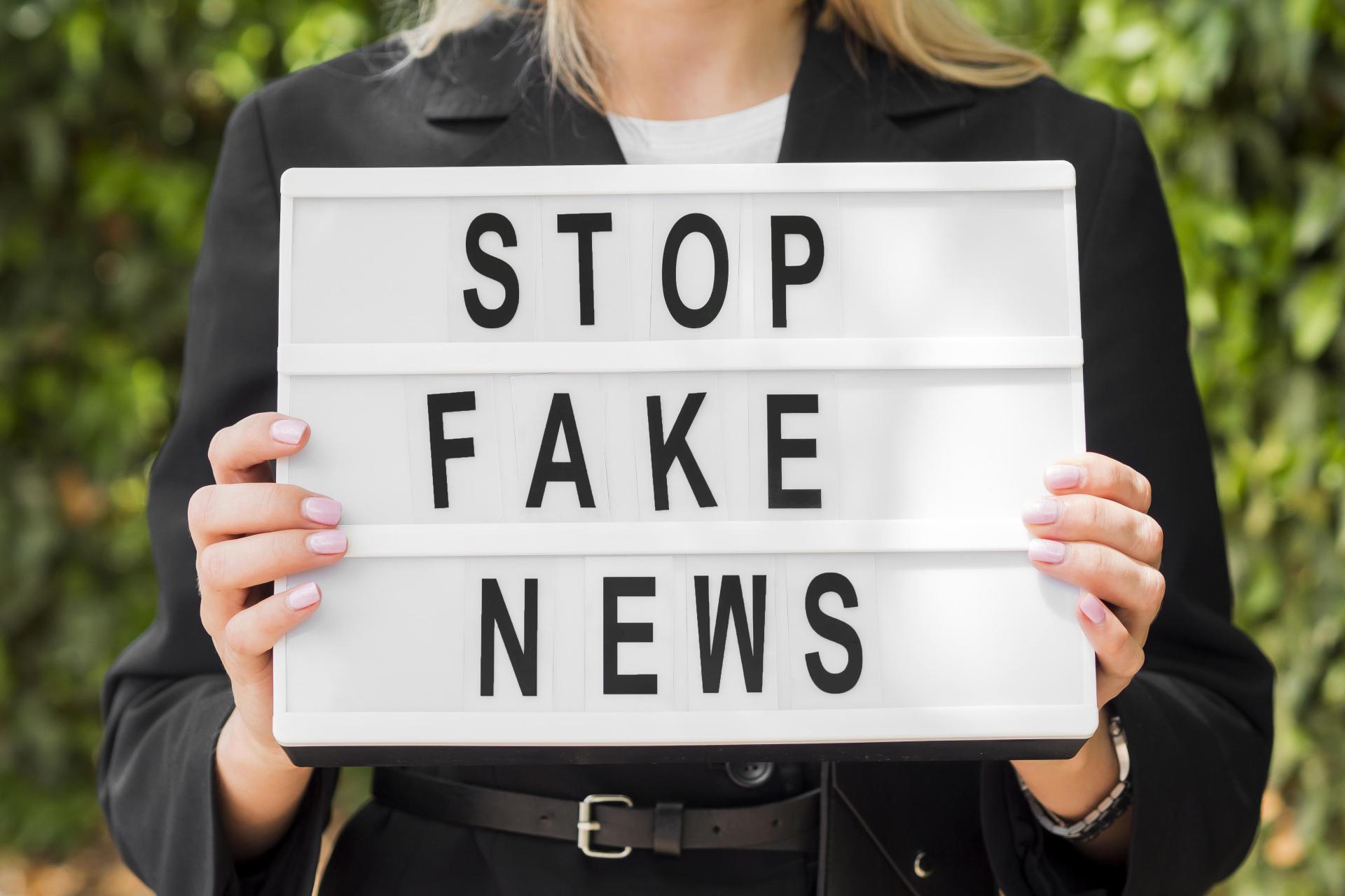 woman-holding-stop-fake-news-sign